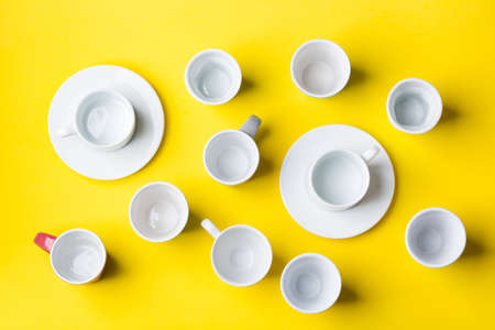 Assortment of coffee cups and mugs with on a yellow background. Creative trendy flat layの写真素材