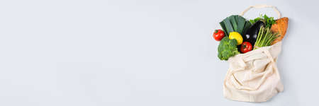 Textile mesh bag with produce, fruits and vegetables. Zero waste, eco-friendly, plastic free recycled, reusable concept. Copy space, flat lay bleached coral background, banner の写真素材