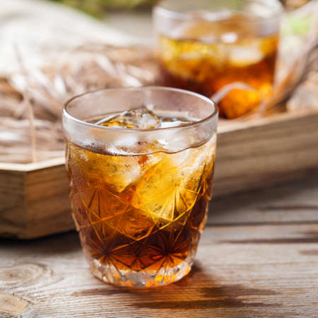Old fashioned italian cocktail negroni with dry gin,   martini rosso vermouth and ice on a wooden table. Summer refreshing beverageの写真素材