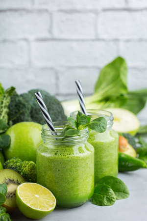 Food and drink, healthy dieting and nutrition, lifestyle, vegan, alkaline, vegetarian concept. Green smoothie with organic ingredients, vegetables on a modern kitchen tableの写真素材