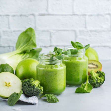 Food and drink, healthy dieting and nutrition, lifestyle, vegan, alkaline, vegetarian concept. Green smoothie with organic ingredients, vegetables on a modern kitchen table. Copy space backgroundの写真素材
