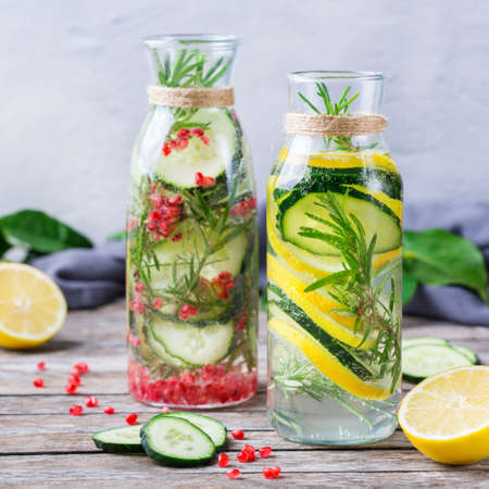Health care, fitness, healthy nutrition diet concept. Fresh cool lemon cucumber rosemary pomegranate infused water, detox drink, lemonade in a glass jar for spring summer daysの写真素材