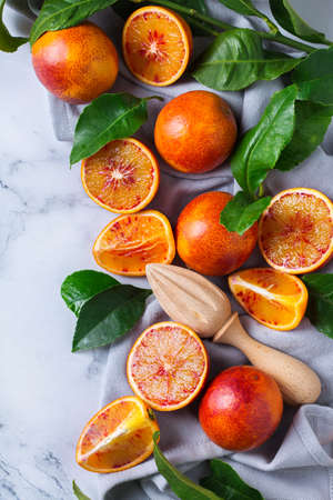Vitamin, clean eating, healthy food vegan concept. Whole and sliced sweet sicilian blood oranges on a white marble table. Top view flat lay backgroundの写真素材