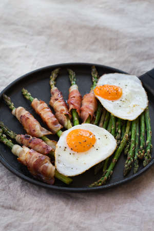 Balanced diet nutrition keto food concept. Healthy ketogenic low carb breakfast or meal, lunch, fried eggs, bacon, asparagus in a cooking pan.の写真素材