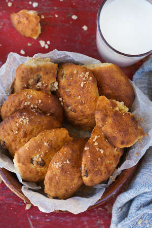Homemade healthy oatmeal cookies with raisins and glass of milk on an old rustic wooden background.の写真素材