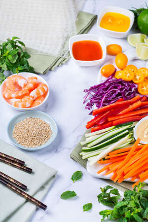 Spring or summer rolls preparation with rice paper, carrot, chili sauce, red cabbage, zucchini ,...