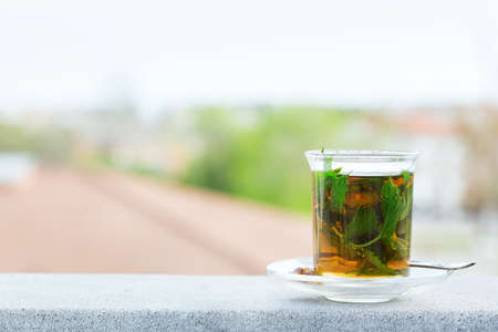 Drink for stress, anxiety, chronic fatigue, depression relieving and relaxation. Glass of hot mint tea with cane sugar, traditional Middle East, moroccan, arabic, moorish beverage.の写真素材