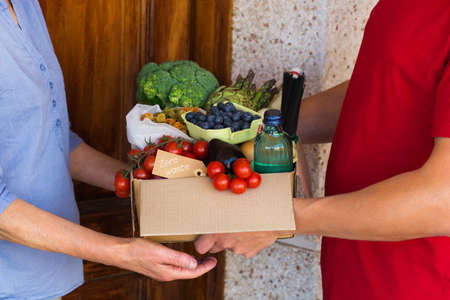 Zero waste no plastic home delivery service. Courier, man holding in hands box of food in recyclable and reusable, eco friendly package. Online internet order, shopping. Sustainable lifestyle conceptの写真素材