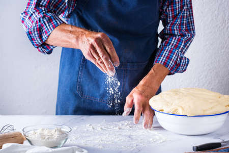 Baking, eating at home, healthy food and lifestyle concept. Senior baker man cooking, kneading fresh...
