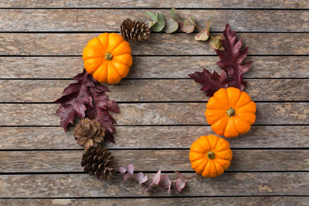 Creative autumn fall thanksgiving day composition with decorative dried leaves. Flat lay, top view, copy space, still life wooden background for greeting card. Floral, botanical concept.の写真素材