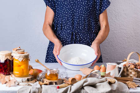 Happy senior mature woman, grandmother cooking, kneading dough, baking pie, cake,  cookies. Autumn...