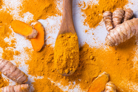 Food and drink, diet nutrition, health care concept. Raw organic orange turmeric root and powder, curcuma longa on a cooking table. Indian oriental low cholesterol spices.の写真素材