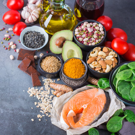 Balanced diet food concept. Assortment of healthy food low cholesterol, spinach avocado red wine green tea salmon tomato flax chia seeds turmeric garlic nuts olive oilの写真素材