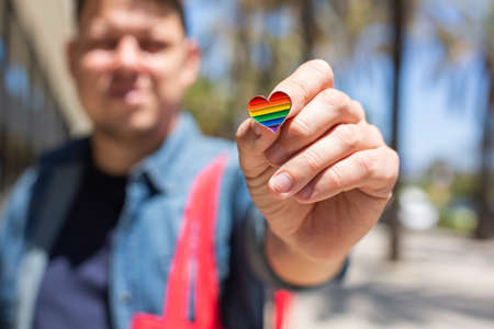 Man with rainbow reusable bag and lgbt badge, pride monthの写真素材