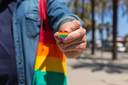 Man with rainbow reusable bag and lgbt badge, pride monthの写真素材