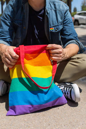 Man with rainbow reusable bag and lgbt badge, pride monthの写真素材