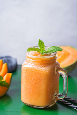 Fresh organic melon cantaloupe smoothie on a kitchen tableの写真素材