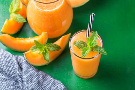 Fresh organic melon cantaloupe smoothie on a kitchen tableの写真素材