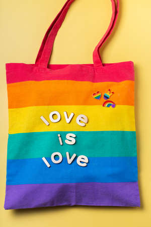 Love is love text, rainbow reusable bag against yellow backgroundの写真素材