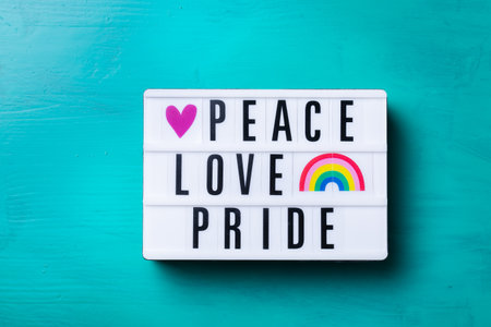 Peace love pride text, rainbow lgbtq flag against turquoise backgroundの写真素材