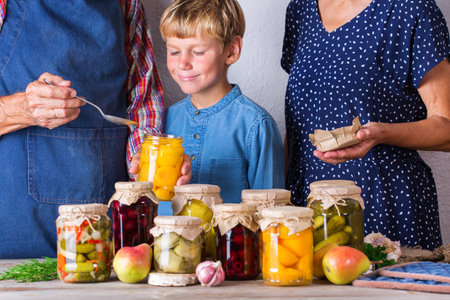 Senior couple with grandson tasting fruit compote. Harvest preservationの写真素材