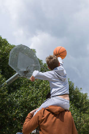 Stylish young boy, teenager is playing with ball, outdoors