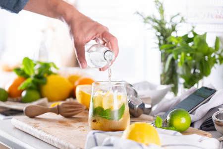 Mixologist making refreshing cocktail with hard seltzer at homeの写真素材