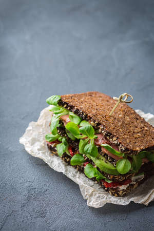 Fresh rye bread sandwich with ham, lettuce and tomatoの写真素材