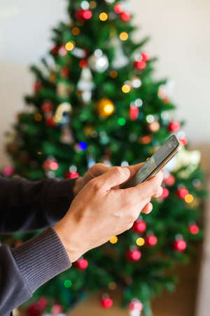 Man buying Christmas, New Year gifts online using phone, laptop