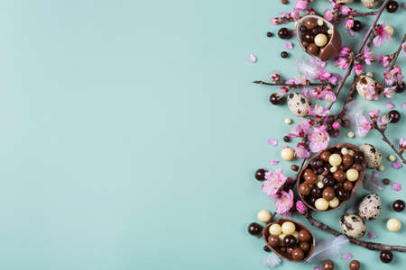 Festive Easter background, chocolate sweets, quail eggs and blooming almondの写真素材