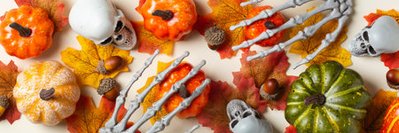 Halloween greeting card with pumpkin, skulls, bony hands and leavesの写真素材