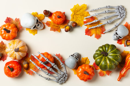 Halloween greeting card with pumpkin, skulls, bony hands and leavesの写真素材