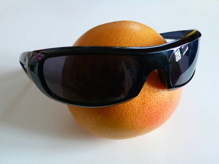 grapefruit with dark glasses as a jokeの写真素材