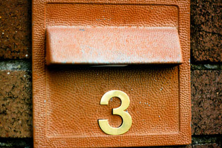 Number 3 in gold on a letter boxの写真素材