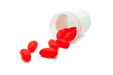 Red tablets flowing out on a containerの写真素材