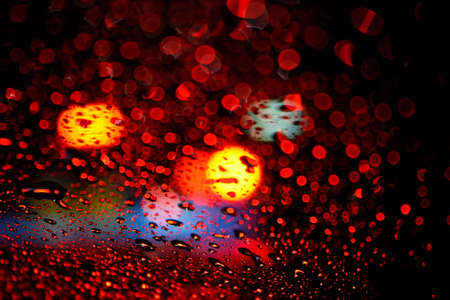 Bokeh of soft-focus red and blue lights trough water drops 