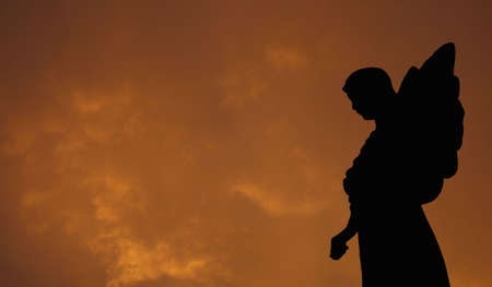 Silhouette of a Statue of an Angel with Storm Cloudsの写真素材