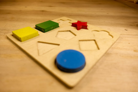 Wooden game for kids with different shapes and colors on the tableの写真素材