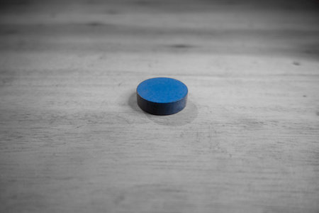 Blue pill on the wooden table. Black and white photo. Selective focus.