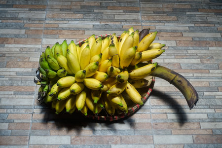 Bunch of bananas in a basket on a wooden floor. Selective focus.の写真素材