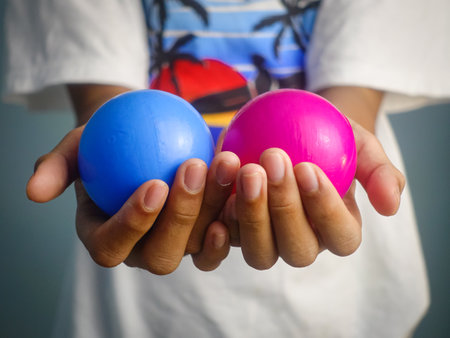Children's hands hold a ball of colored plastic. The concept of children's games.