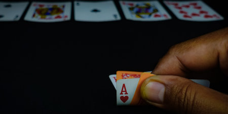Playing cards on black table in casino. Close up of hand holding two acesの写真素材