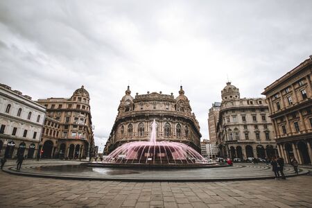 GENOA, ITALY - APRIL 8, 2016. Panoramic view of De Ferrari square in Genoa, the heart of the city with the central fountain and the Stock Exchange palace. Pink water in fountain on Piazza De Ferrariのeditorial素材