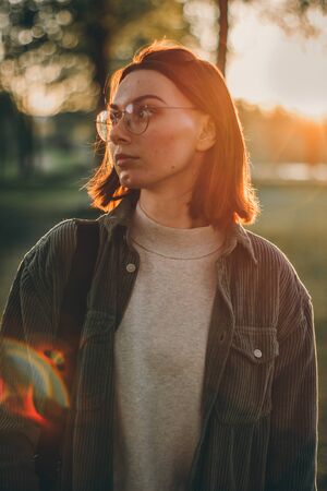 Closeup outdoor portrait of stylish beautiful caucasian young woman with short brunette hair wearing...