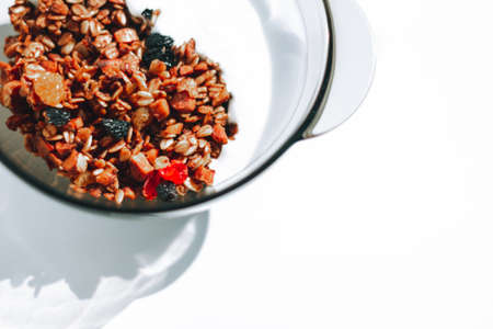Homemade granola with berries and yogurt for breakfast on the white background, close-up, top view, horizontalの写真素材