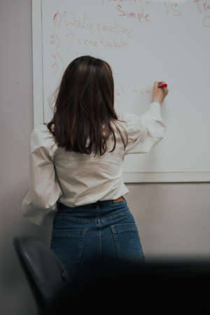 Female teacher writing on the marker board im classroom. Education concept english language lessonの写真素材