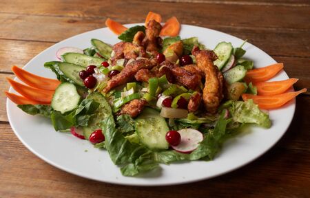 Roast meat with fresh vegetables on wooden tableの写真素材