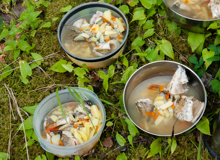 Dishes with fish soup on wood ground outdoorの写真素材