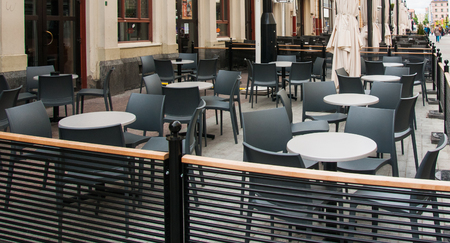 Tables and chairs for cafe in street in summer