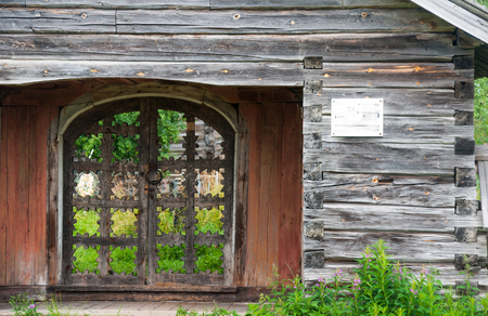 Old wooden carved gate in wooden fence, Russiaの写真素材